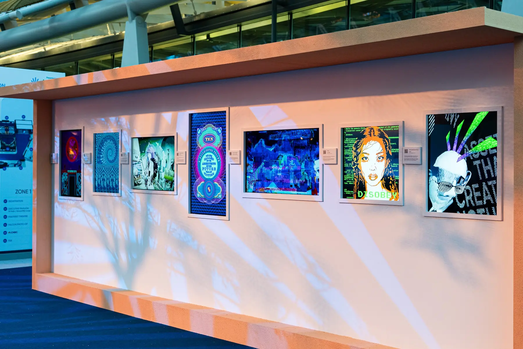 An outdoor exhibition wall of framed digital artworks under warm light at Abu Dhabi Finance Week