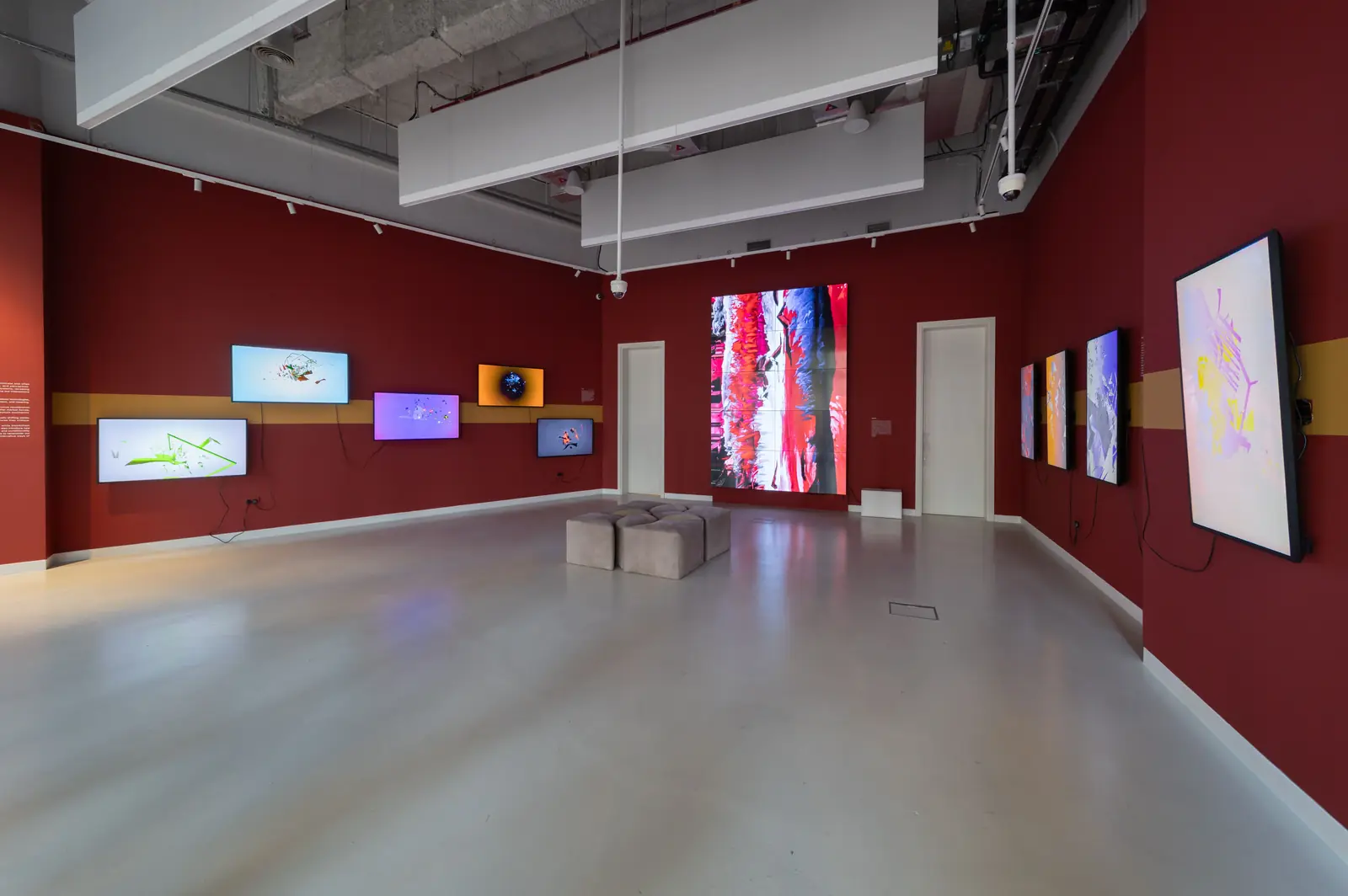 Red gallery with screens and a tall LED video wall