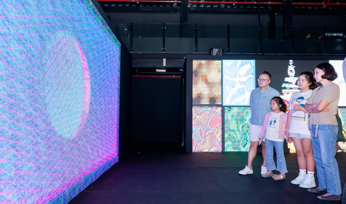 A family photographing themselves in front of an LED wall