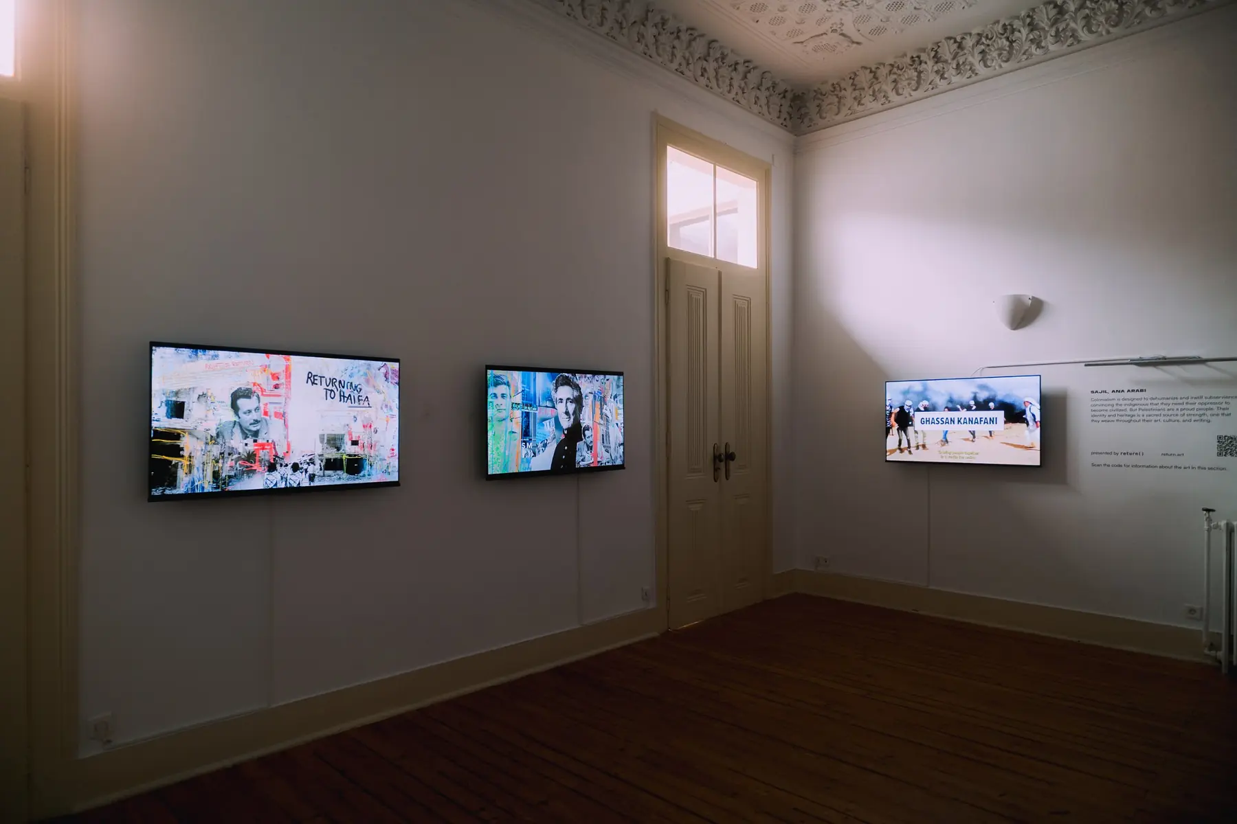 Screens in a bright room with ornate plaster ceilings at Palacete Gomes Freire