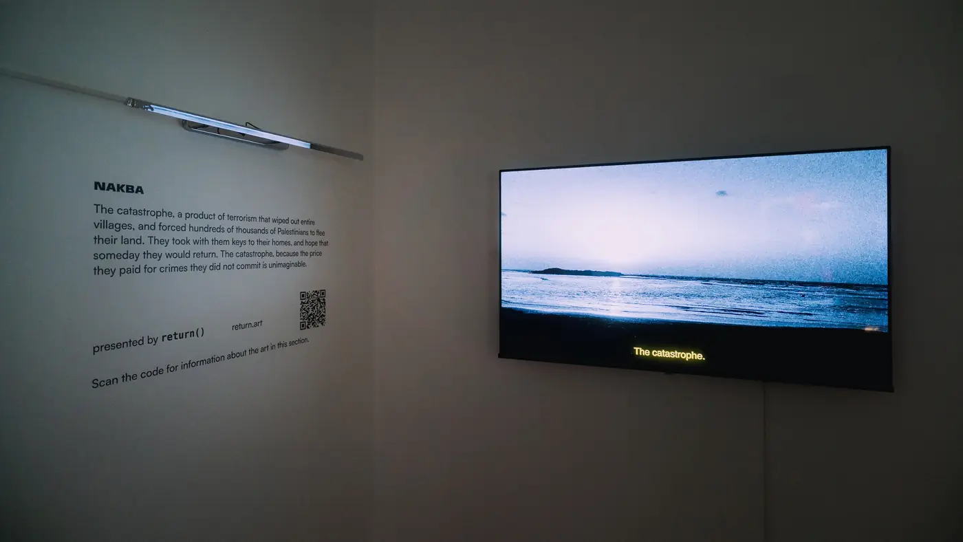 Wall text titled Nakba beside a screen showing a seascape